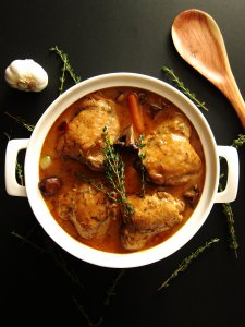 Instant Pot Coq Au Vin P1 - chicken and carrots in gravy in a large white pot with thyme sprigs sprinkled on top - Paint the Kitchen Red