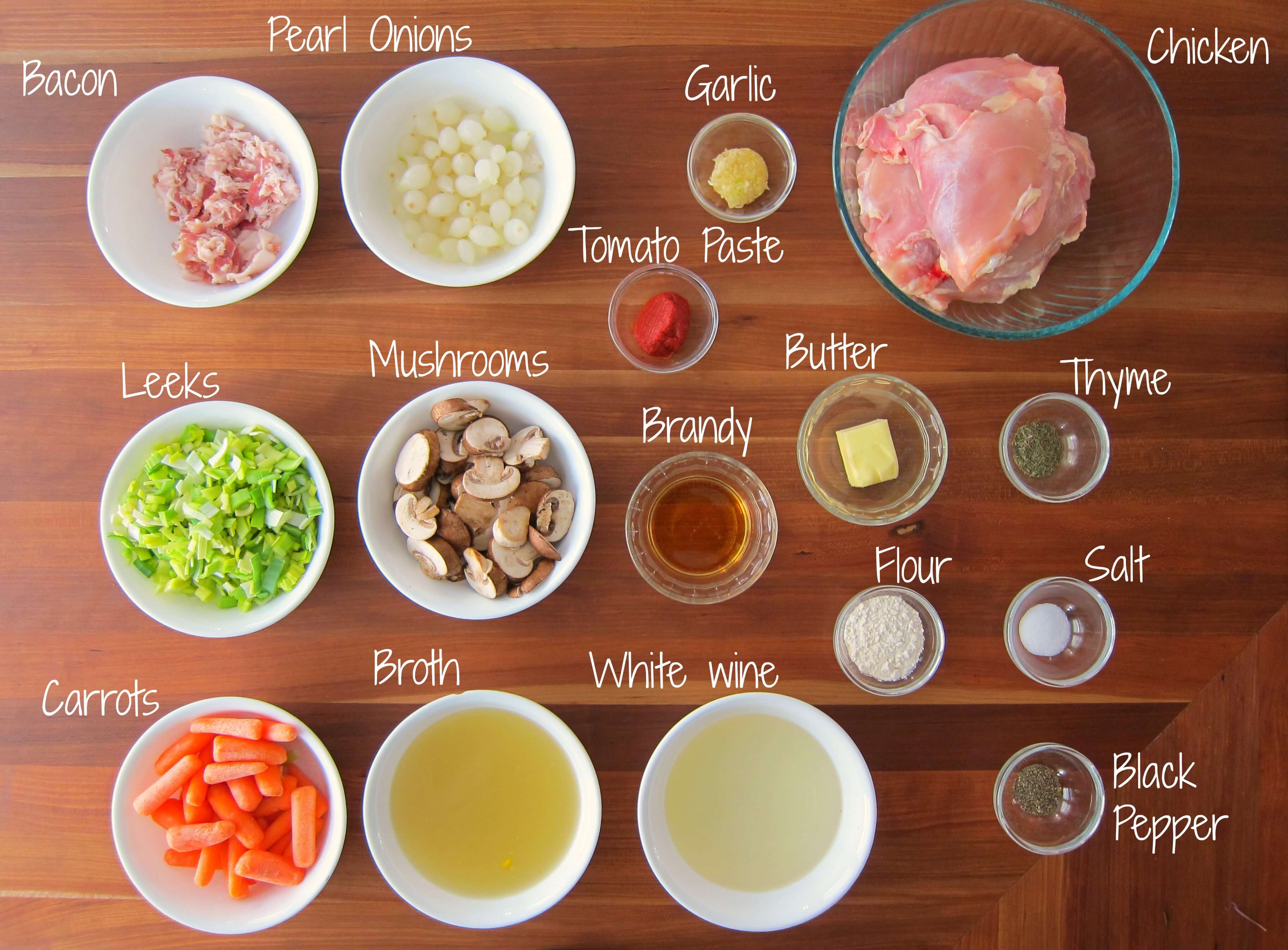 Instant Pot Coq au Vin Blanc Ingredients - bacon, pearl onions, garlic chicken, leeks, mushrooms, brandy, tomato paste, butter, thyme, flour, salt, carrots, broth, white wine, black pepper