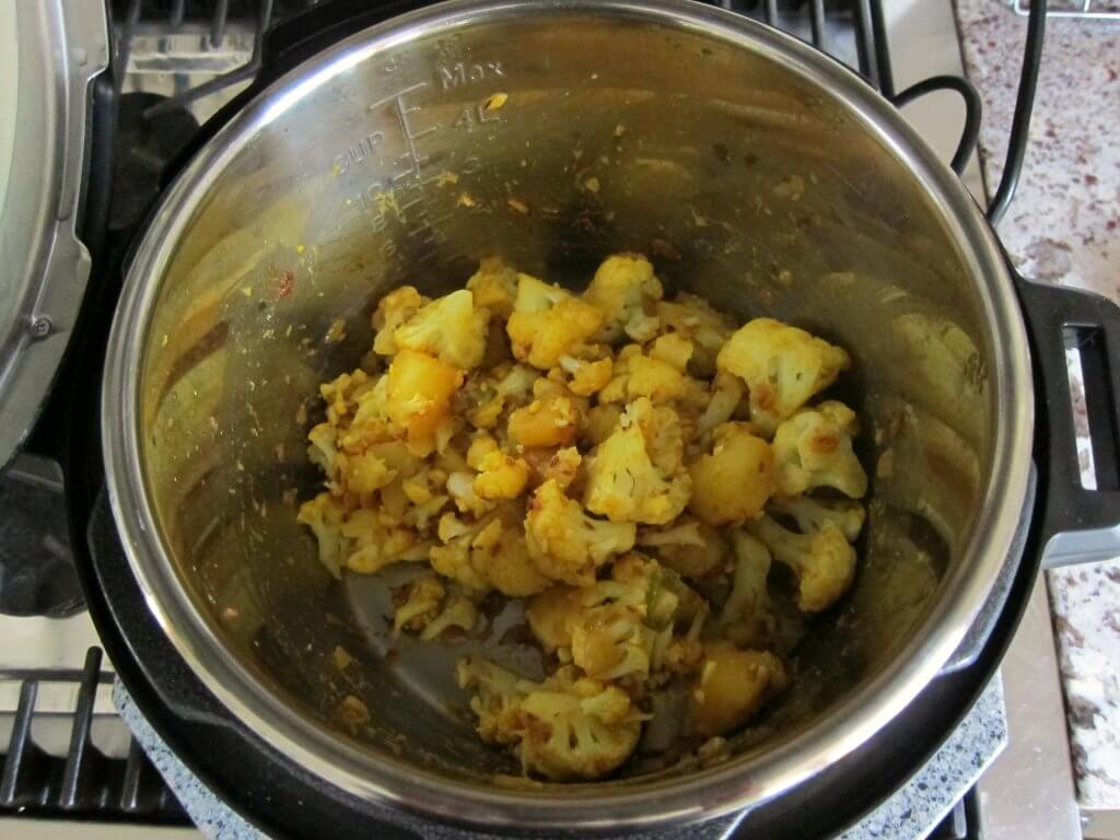 Instant Pot Aloo Gobi open Instant Pot with cooked aloo gobi