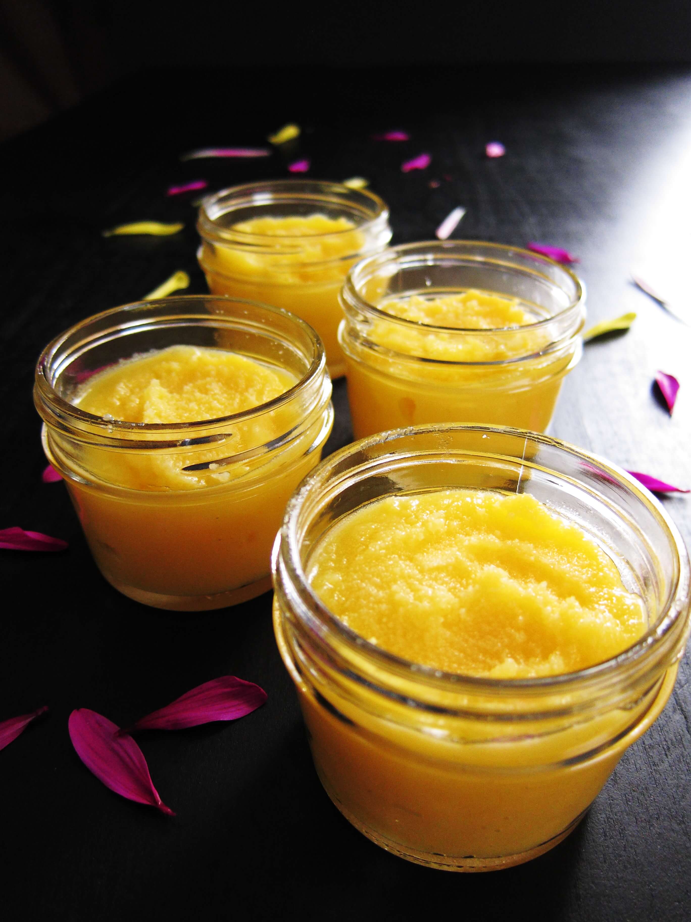 Instant Pot Ghee - four mason jars with golden ghee on black background with pink petals - Paint the Kitchen Red