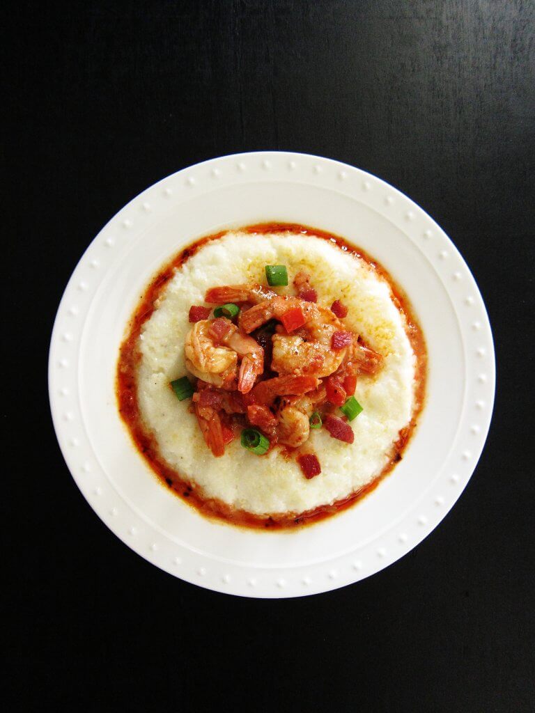 Instant Pot Shrimp and Grits in white bowl garnished with green onions and bacon
