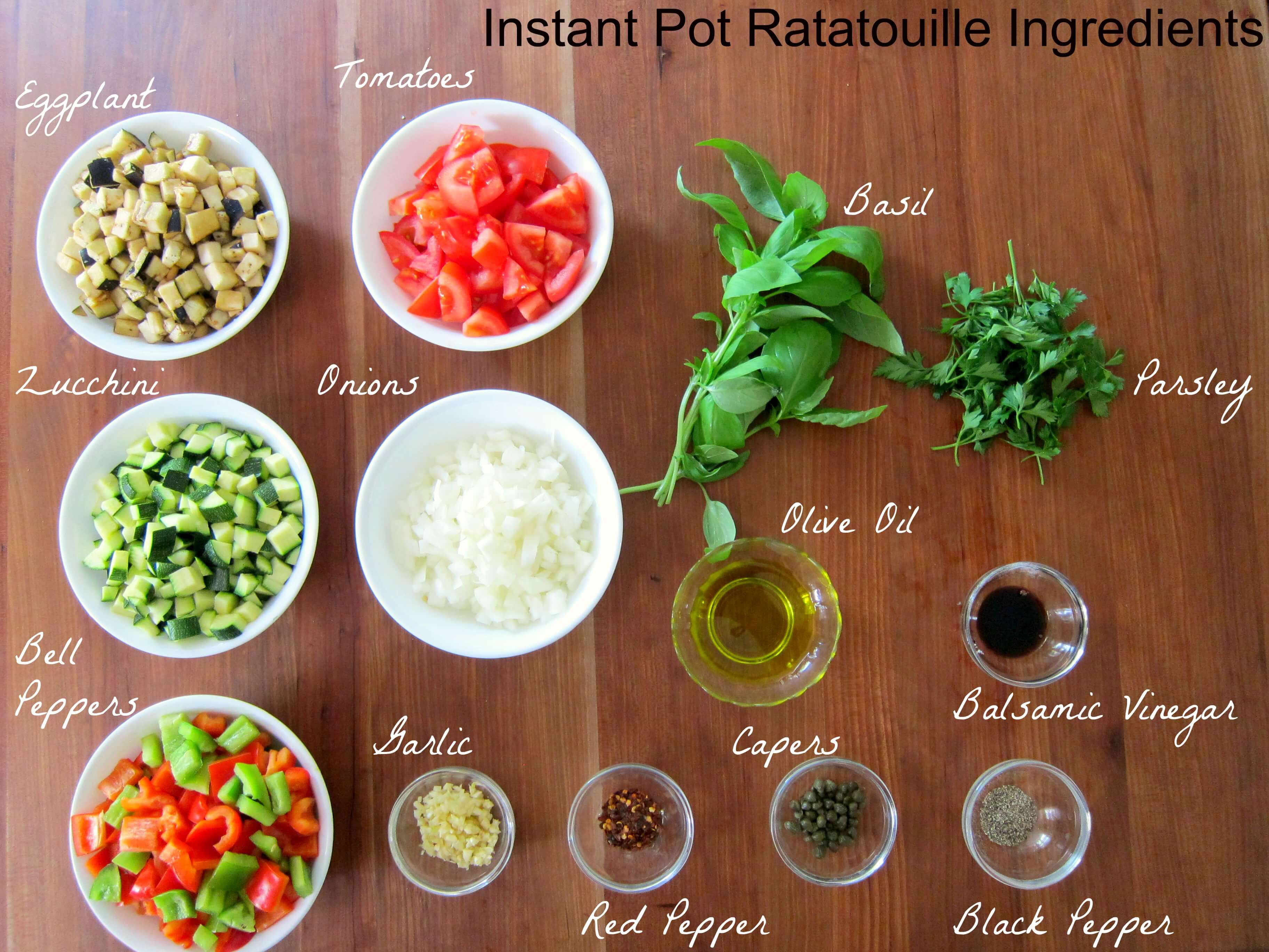 Instant Pot Ratatouille Ingredients - eggplant, tomatoes, basil, parsley, zucchini, onions, olive oil, balsamic vinegar, bell peppers, garlic, red pepper, capers, black pepper