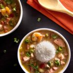 Instant Pot Gumbo with rice in white bowl on black background - Paint the Kitchen Red