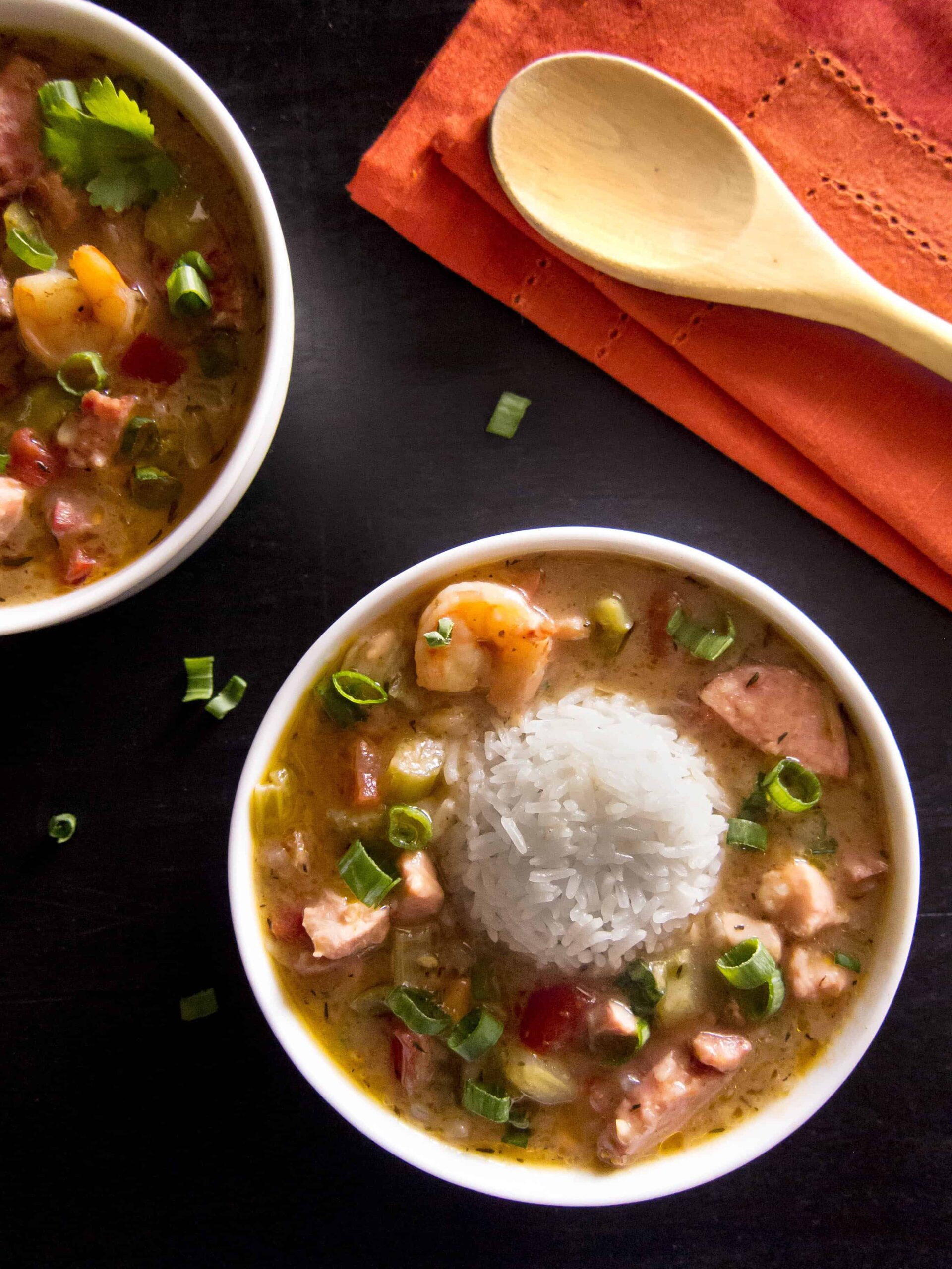 Instant Pot Gumbo with rice in white bowl on black background - Paint the Kitchen Red