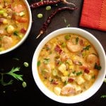 Creamy Instant Pot Chipotle Shrimp Soup colorful with red napkin, dried red chili peppers, parsley and green onions sprinkled on black background - Paint the Kitchen Red