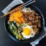 Instant Pot Korean Beef on a bed of rice with sauteed vegetables and fried egg in a black bowl