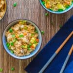 Instant Pot Fried Rice - bowl of rice with vegetables garnished with green onions in blue bowl on blue napkin with chopsticks