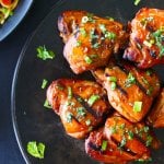 Instant Pot Thai Grilled Chicken Thighs on dark background with sprinkled cilantro and green onions