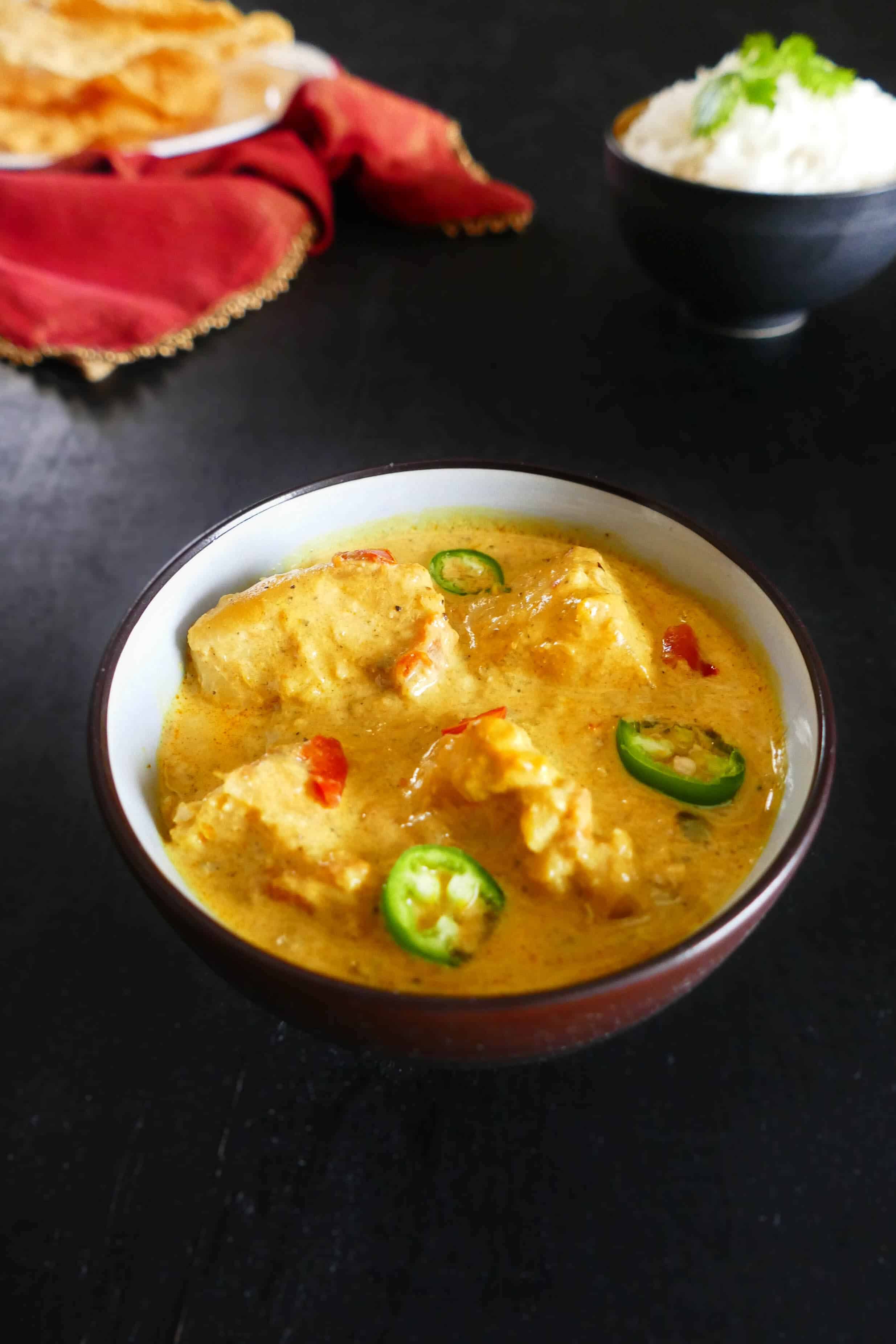 Instant Pot Indian Fish Curry in dark bowl with rice and poppadums