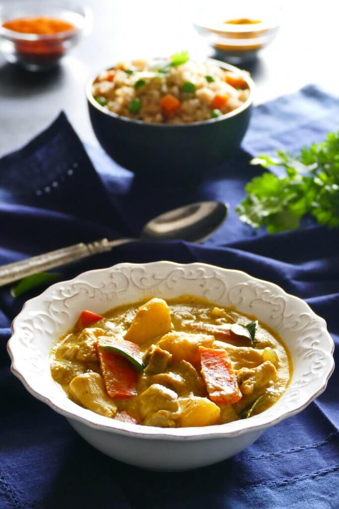 Instant Pot Thai Yellow Curry with Chicken in white bowl on blue napkin, with fried rice in another bowl