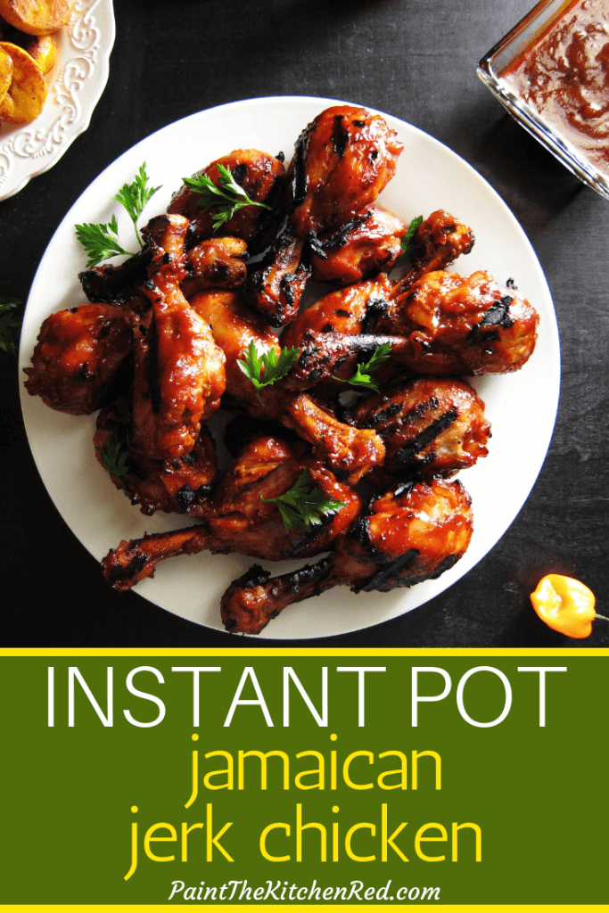 Instant Pot Jamaican Jerk Chicken Pinterest pin with drumsticks on white plate with hot peppers and fried bananas in background - Paint the Kitchen Red
