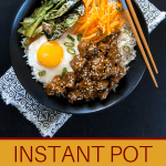 Instant Pot Korean Beef pinterest - rice bowl with beef, fried egg, carrots, greens in black bowl with chopsticks - Paint the Kitchen Red