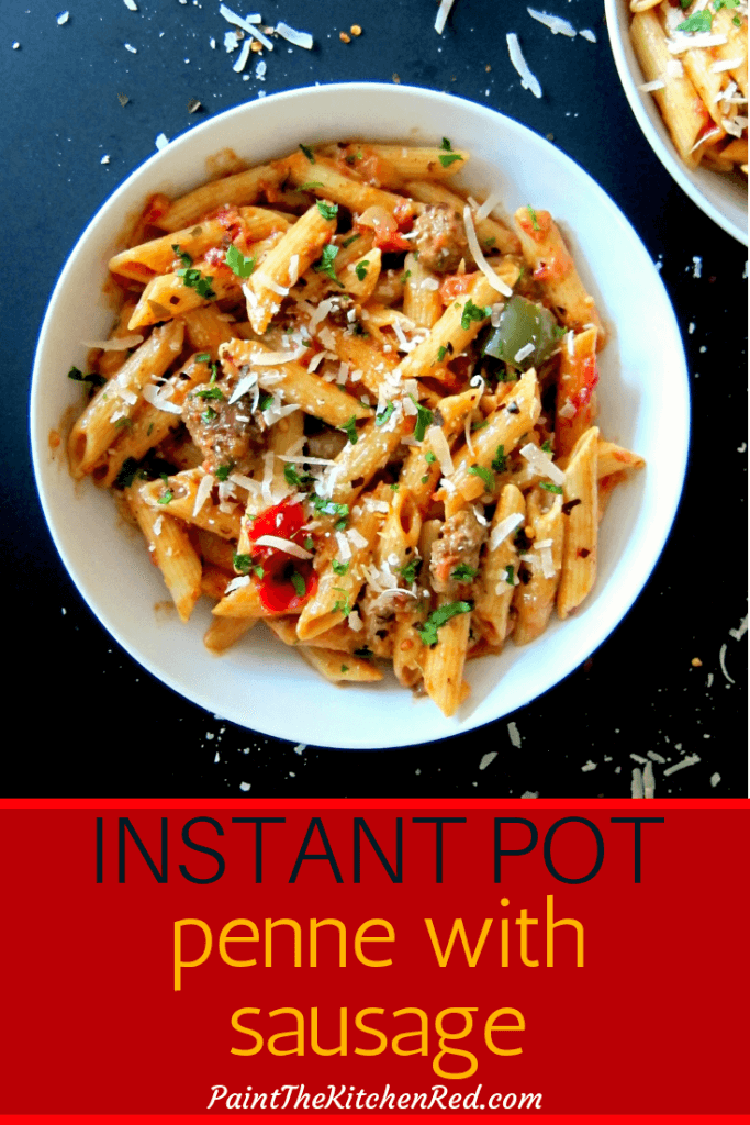 Instant Pot Pasta - Penne with Sausage and Tomato Cream Sauce Pinterest - penne with sausage and red and green bell peppers in white bowl garnished with parmesan and parsley on a black background - Paint the Kitchen Red