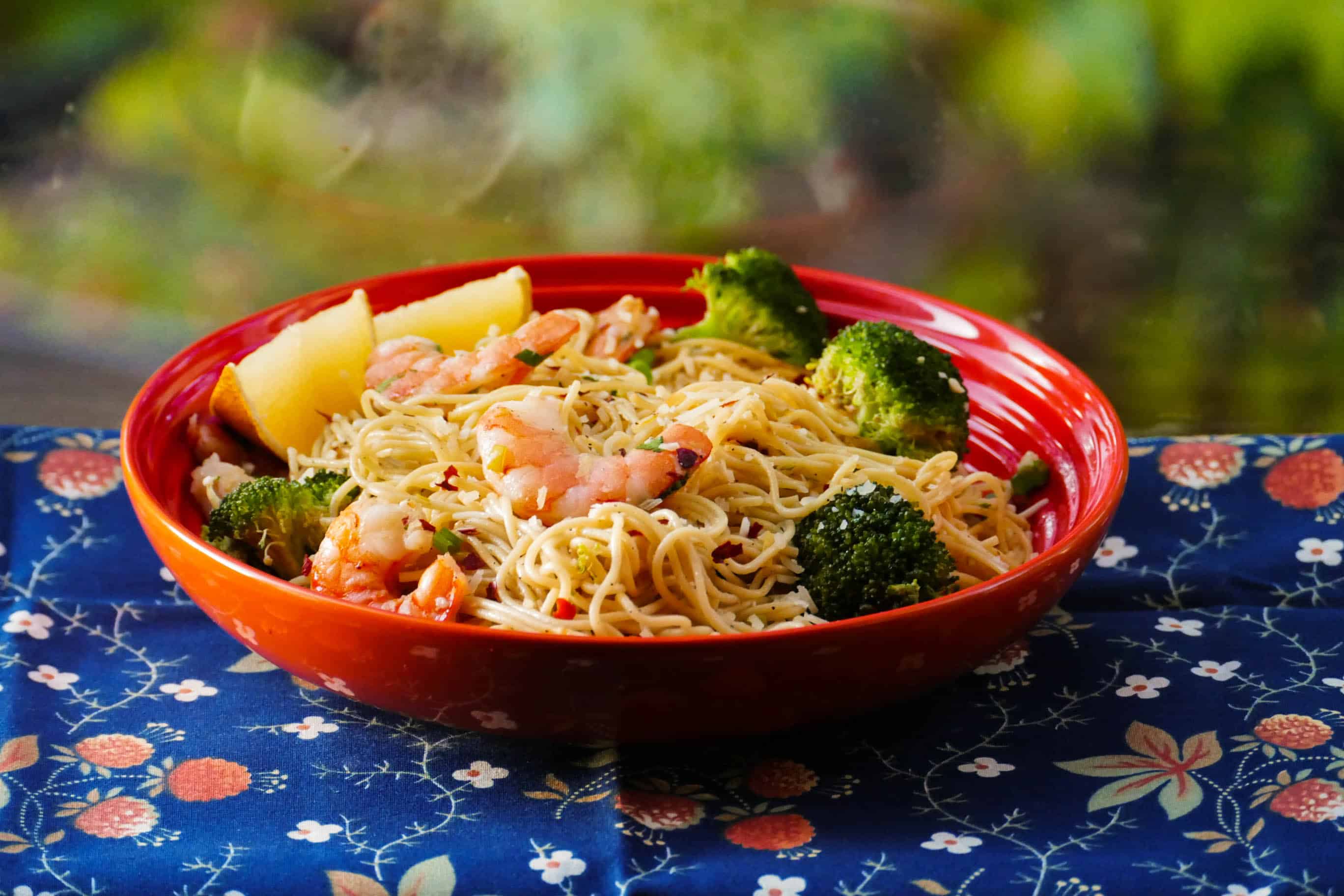 Instant Pot Shrimp Pasta with Garlic, parmesan, broccoli with lemon wedges in orange bowl - Paint the Kitchen Red