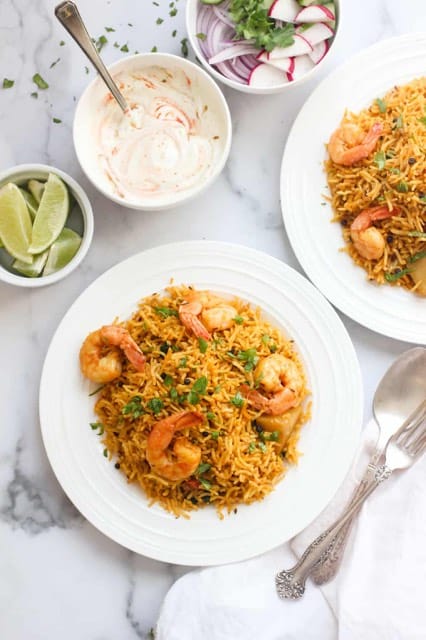 Instant Pot Shrimp Biryani - 2 plate with raita, lime and garnish on the side