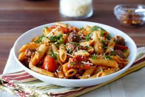 Instant Pot Pasta - Penne Sausage with Tomato Cream sauce in a white bowl- Paint the Kitchen Red