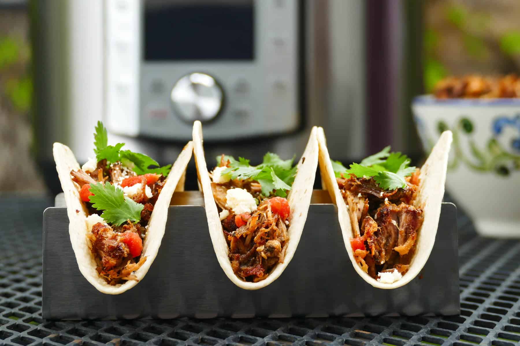 Three Instant Pot Pulled Pork Tacos on a table