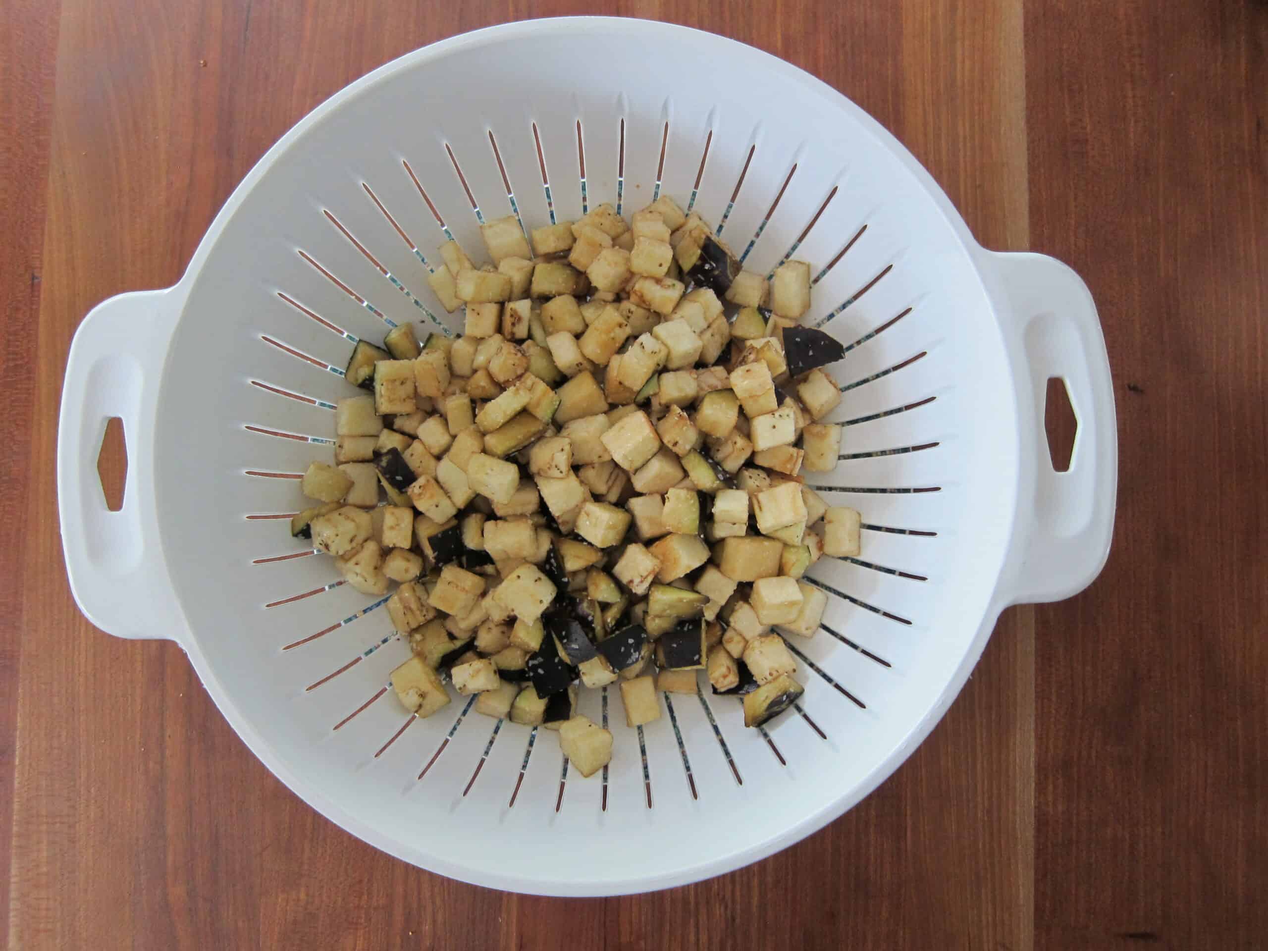 salted eggplant cubes in colander