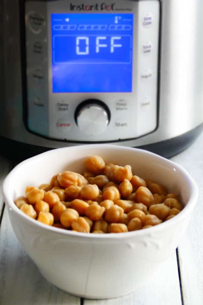 A bowl of cooked chickpeas on a white counter
