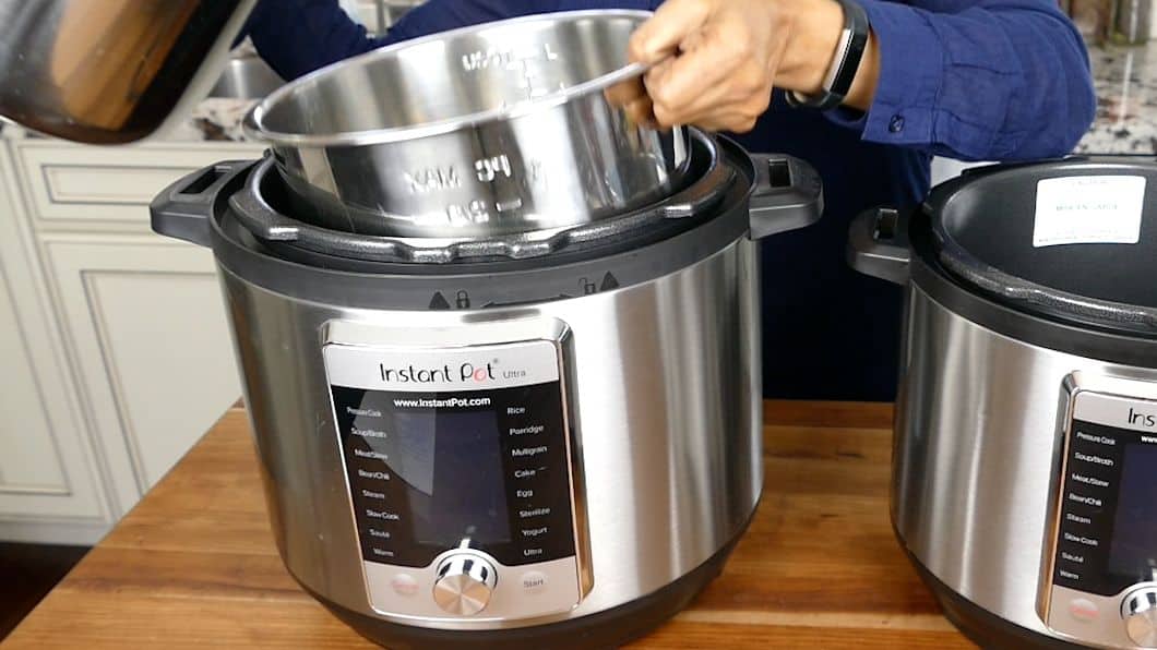 Two instant pots on a counter. 6 quart inner pot being put into 8 quart Instant Pot