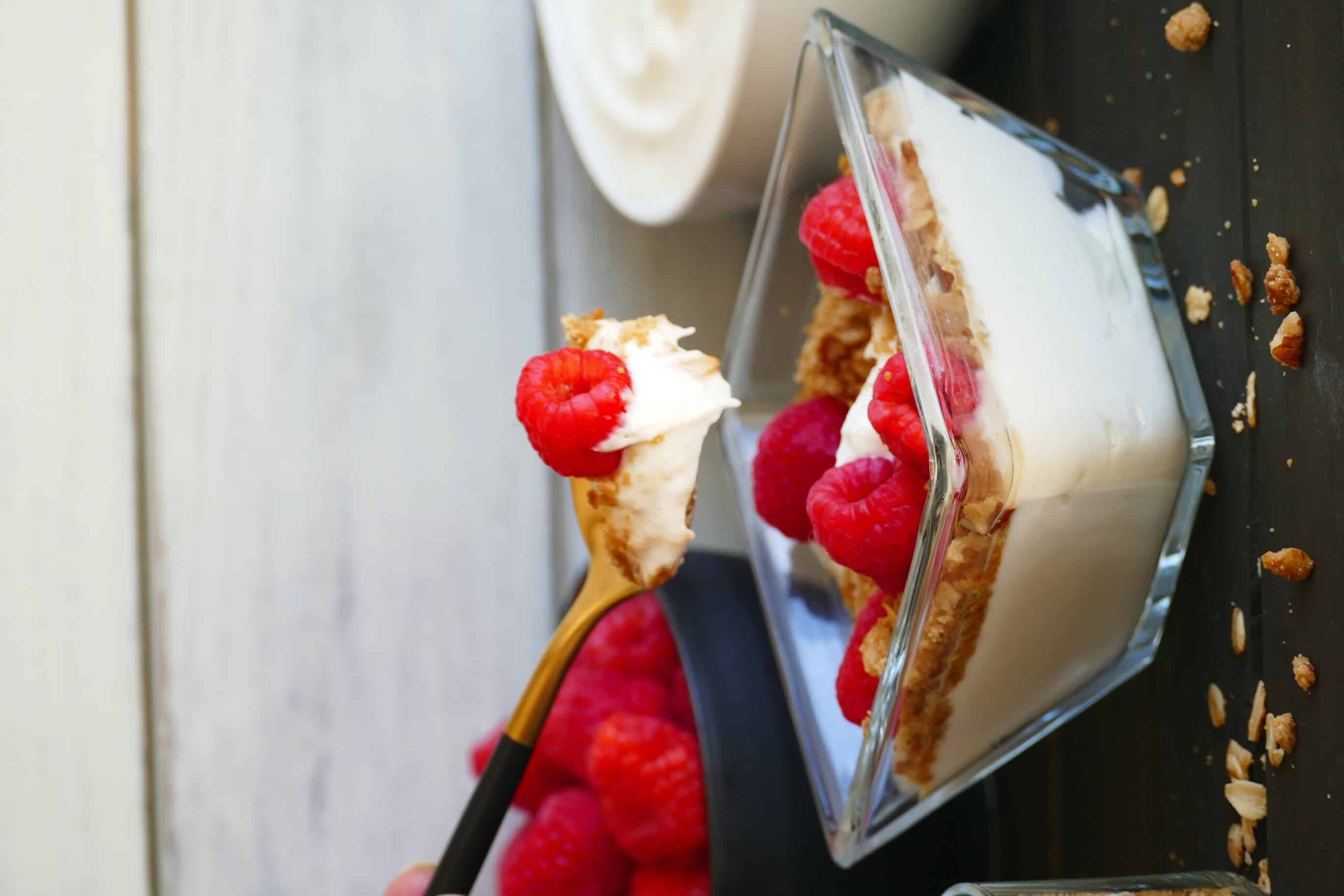 bowl of yogurt with granola and raspberries