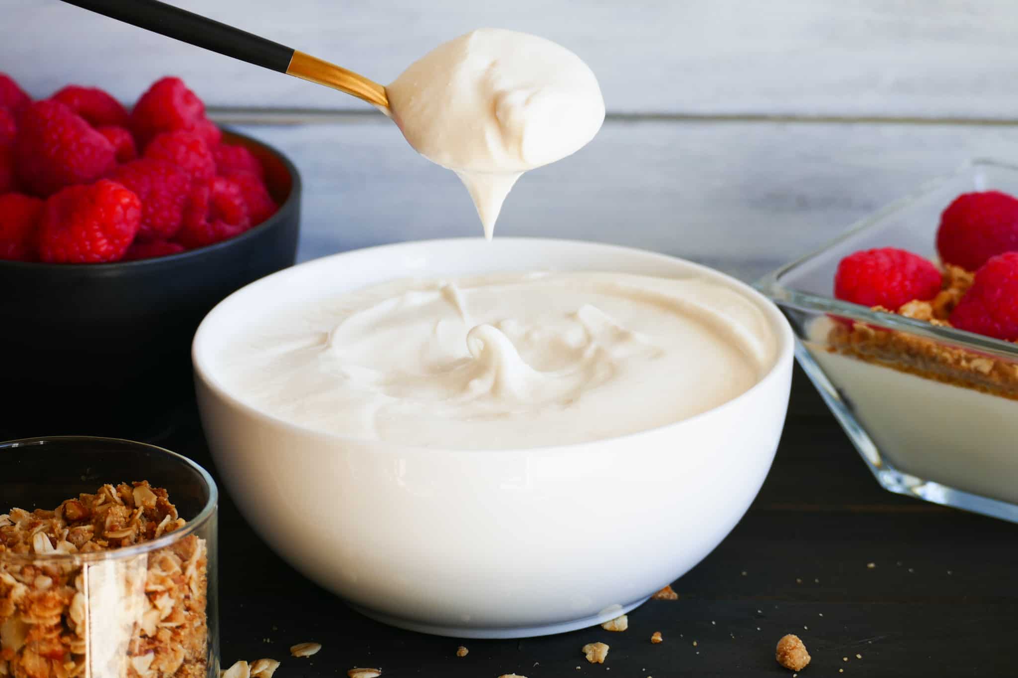 Very thick yogurt being scooped out of bowl with spoon