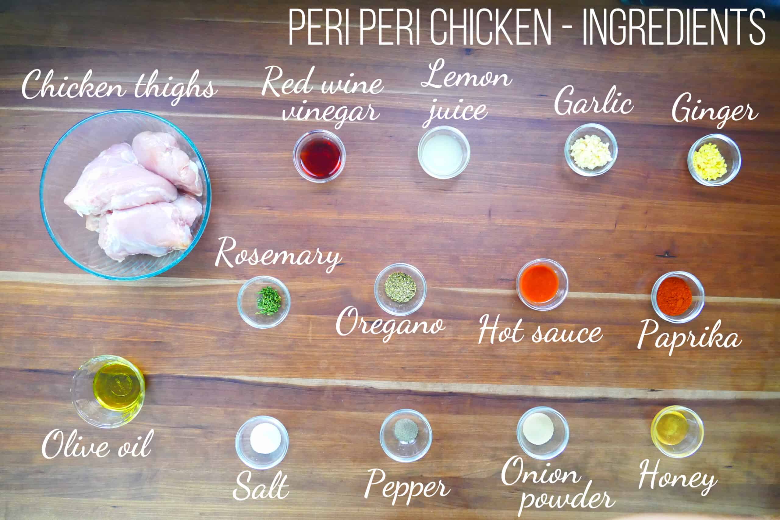 peri peri chicken ingredients - chicken thighs, red wine vinegar, lemon juice, garlic, ginger, rosemary, oregano, hot sauce, paprika, olive oil, salt, pepper, onion powder, honey