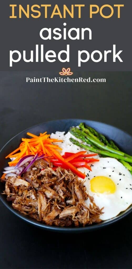 Black bowl with pulled pork, carrots, red onions, bell pepper, asparagus, fried egg and rice on black background