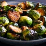 gray speckled bowl with roasted brussel sprouts cut in half