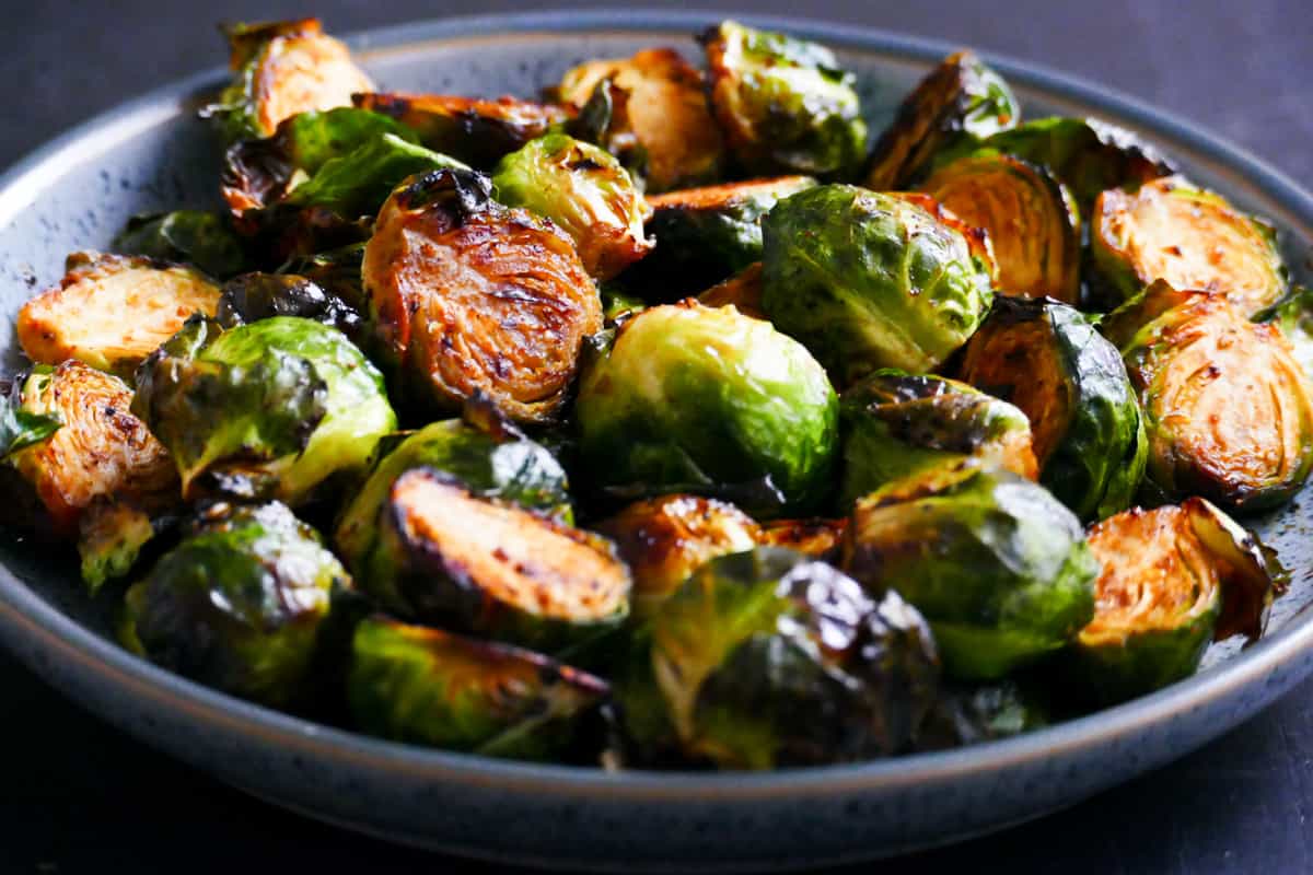 gray speckled bowl with roasted brussel sprouts cut in half