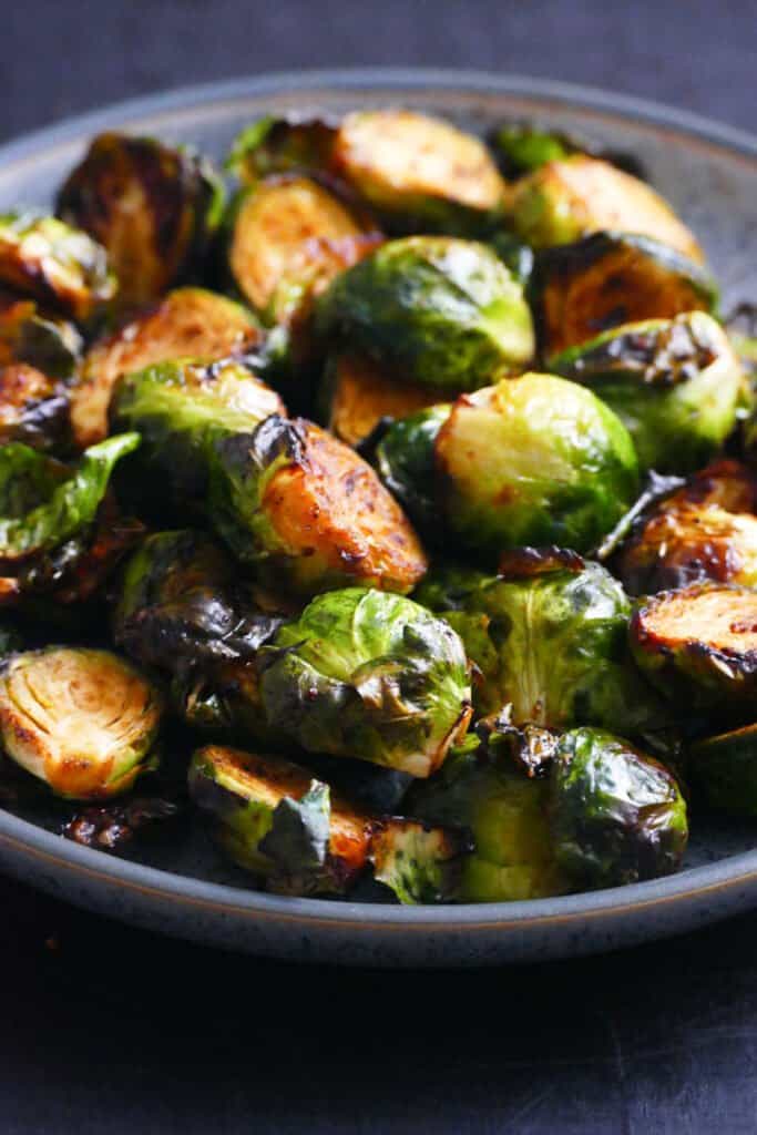 gray speckled bowl with roasted brussel sprouts cut in half