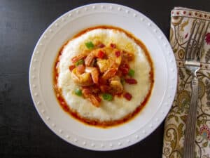 Instant Pot Shrimp and Grits garnished with green onions on a white plate