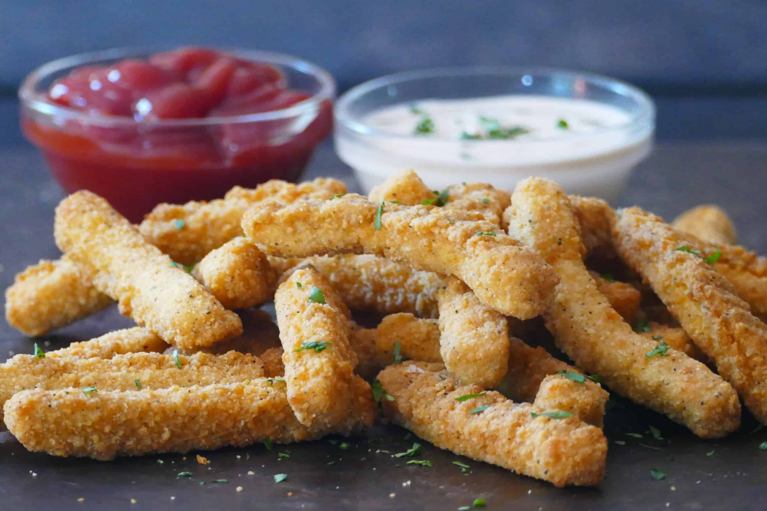 Chicken fries with red and white sauce garnished with parsley