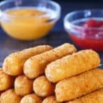 mozzarella sticks stacked on each other on dark surface