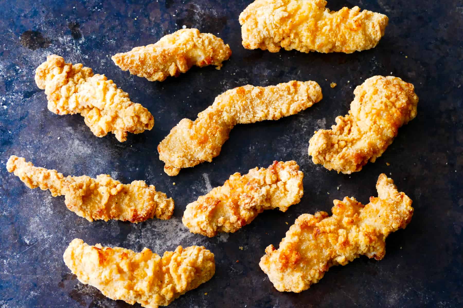 chicken tenders arranged on dark background