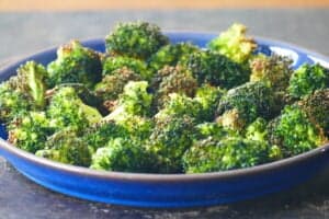 Blue plate with roasted broccoli laid out.