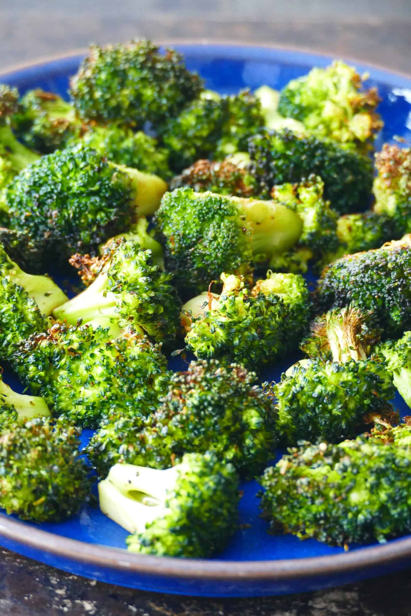 Air fryer broccoli - Blue plate with roasted broccoli laid out.