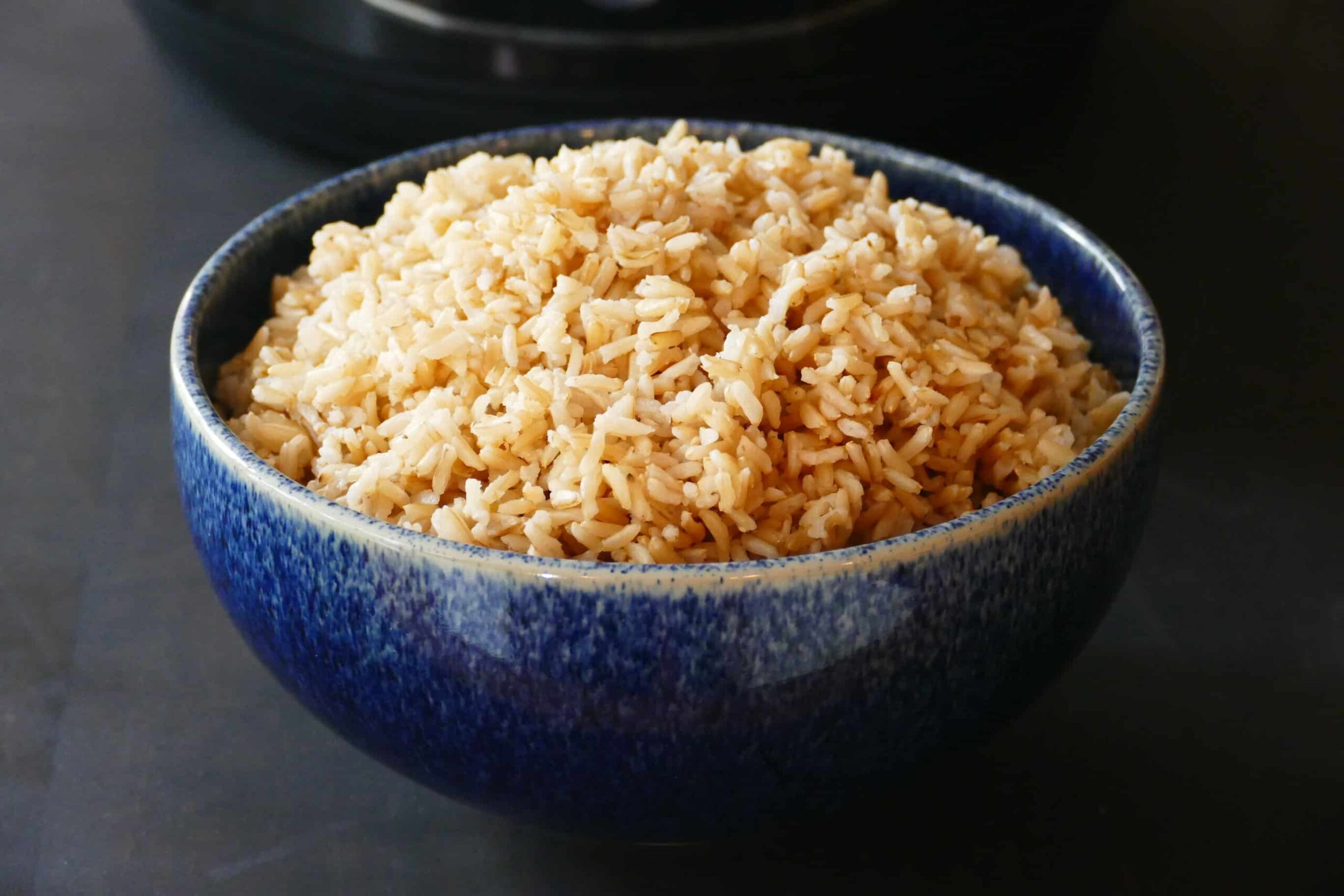 Heaping mound of brown rice in a blue bowl