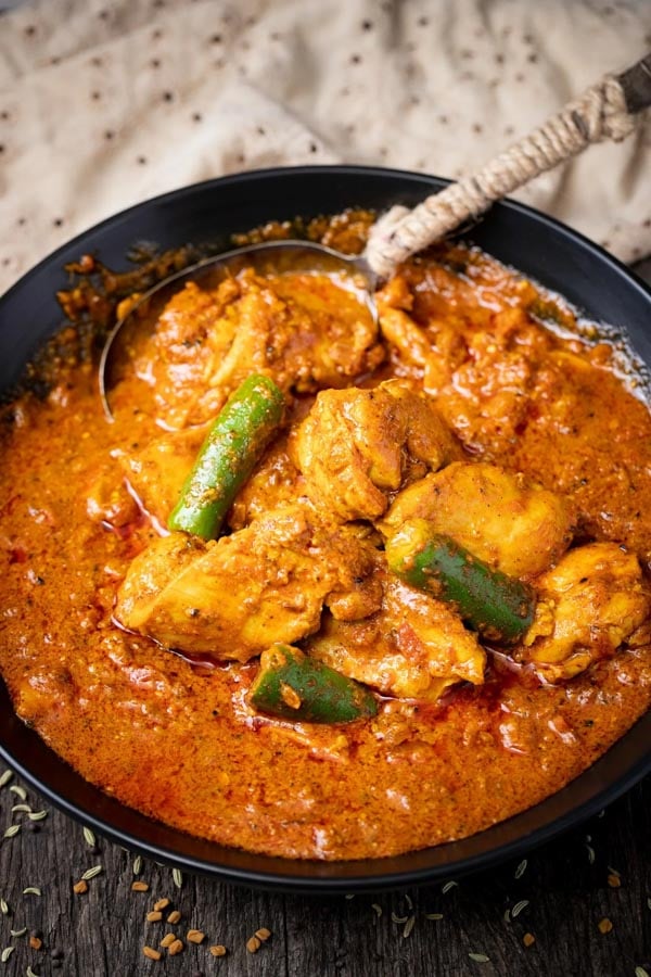 Chicken in black bowl with green chilis