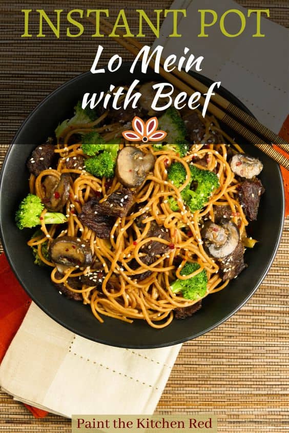 Instant Pot Lo Mein with Beef and Broccoli in black bowl on straw mat with chopsticks laid across bowl.