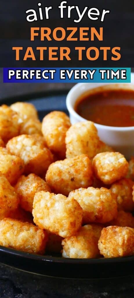 Tater tots stacked on a dark plate with a bowl of red sauce with text 