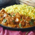 Chicken curry and rice on plate.