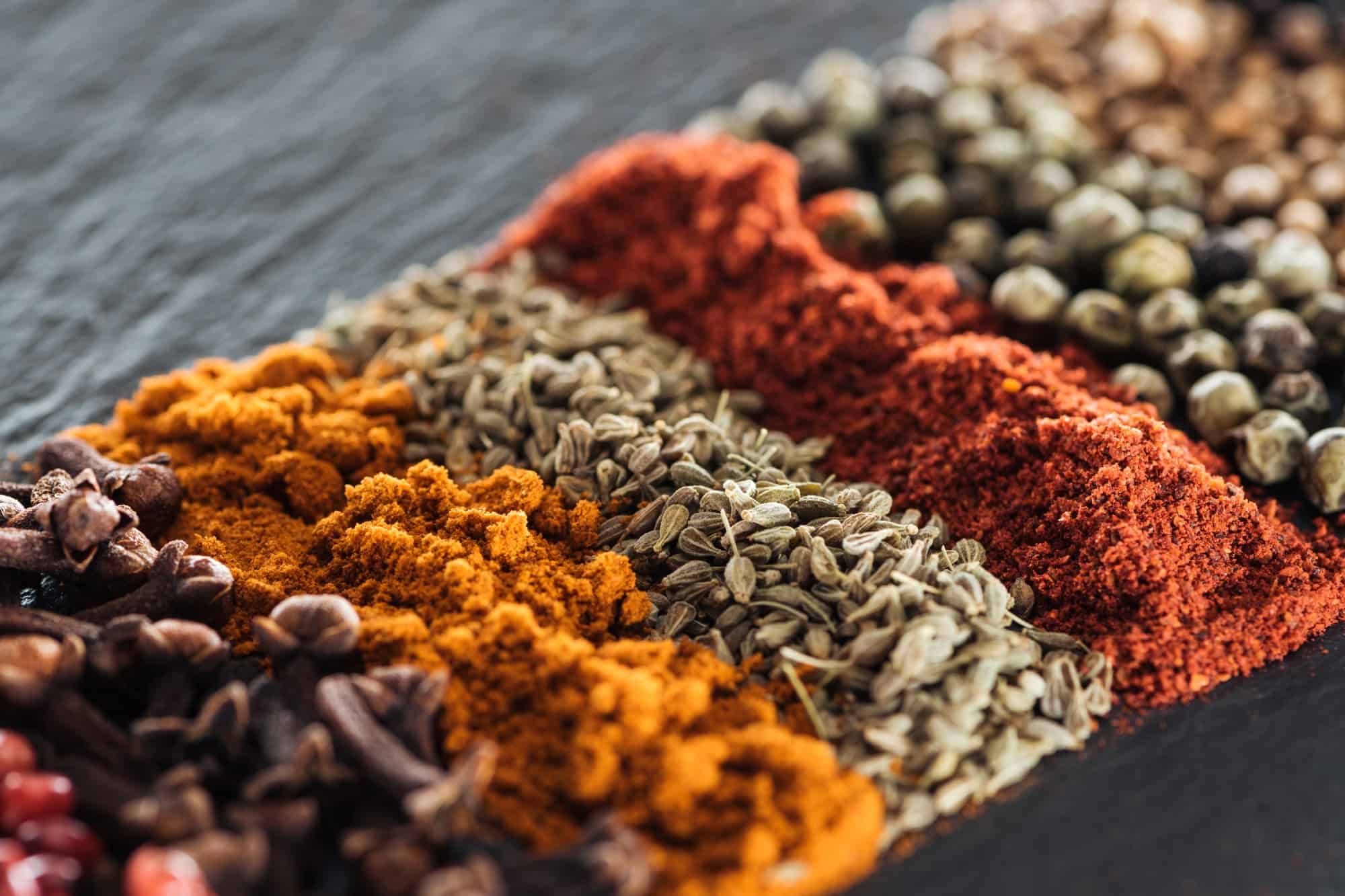 Spices arranged in a row for butter chicken and tikka masala.