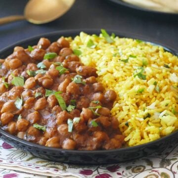 Instant Pot chana masala chickpea curry in a black bowl with yellow rice.