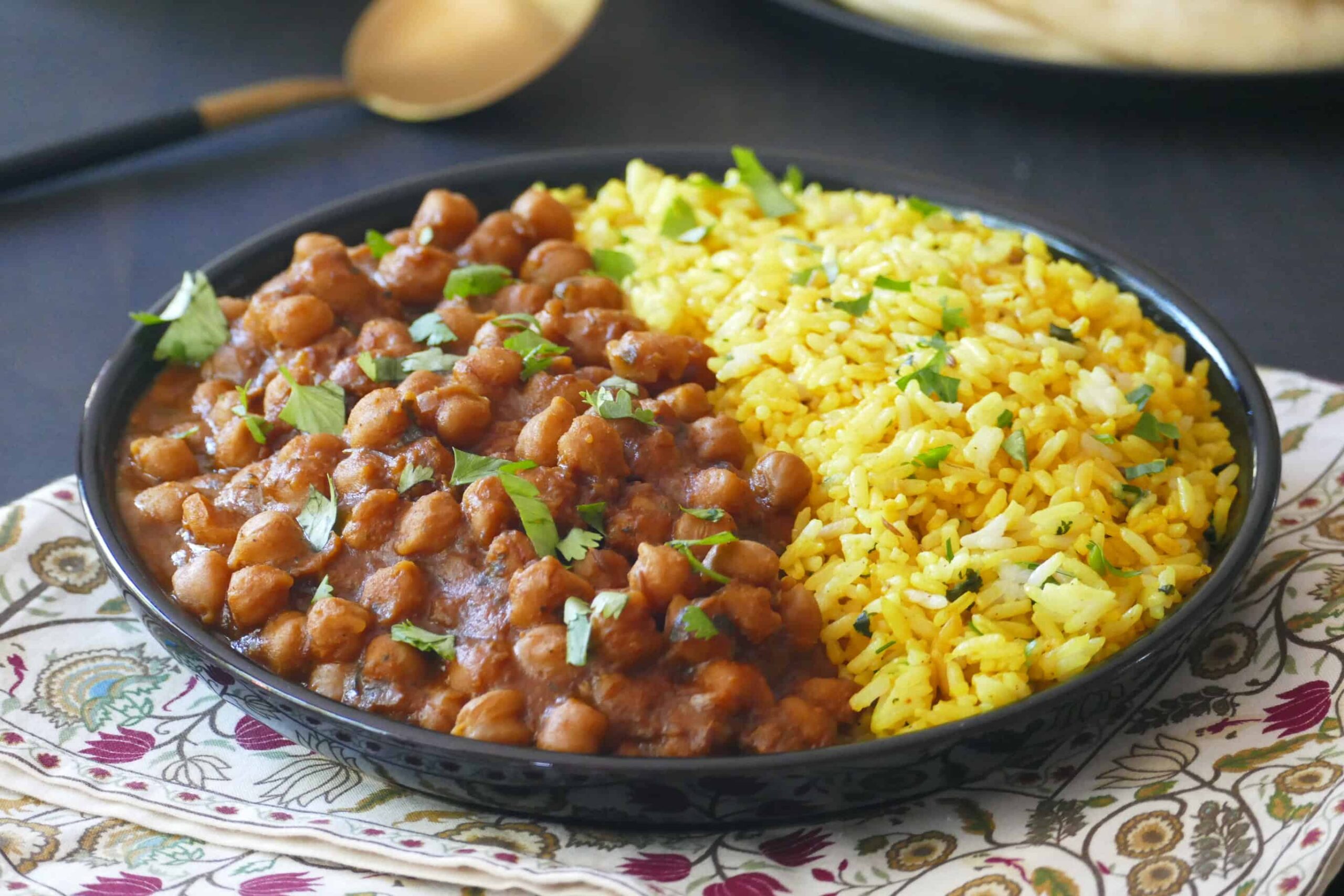 Instant Pot chana masala chickpea curry in a black bowl with yellow rice.