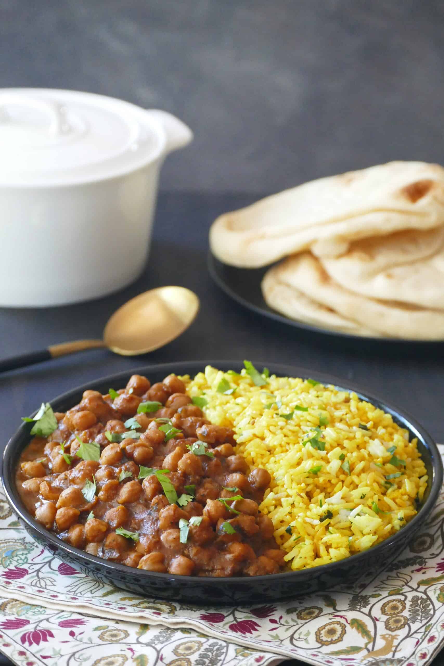 Instant Pot chana masala chickpea curry in a black bowl with yellow rice.