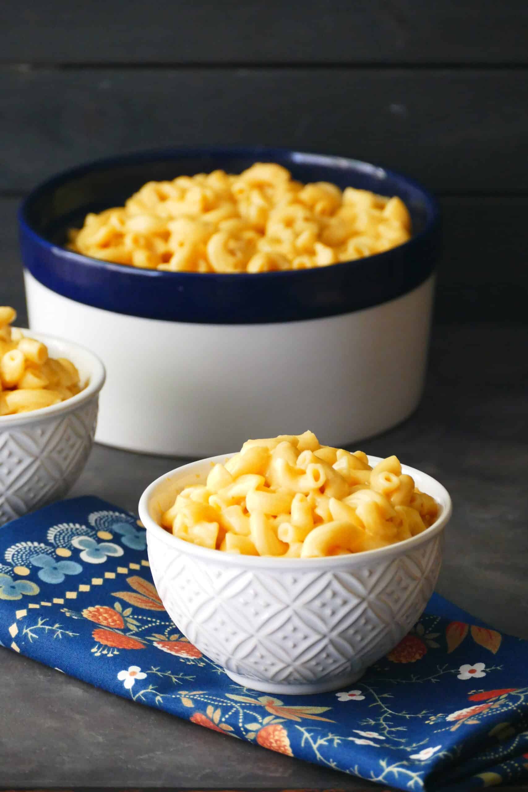 Instant Pot Mac and Cheese in smaller bowls with larger bowl in background.