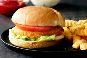 Air fryer frozen chicken patty in a sandwich with french fries.