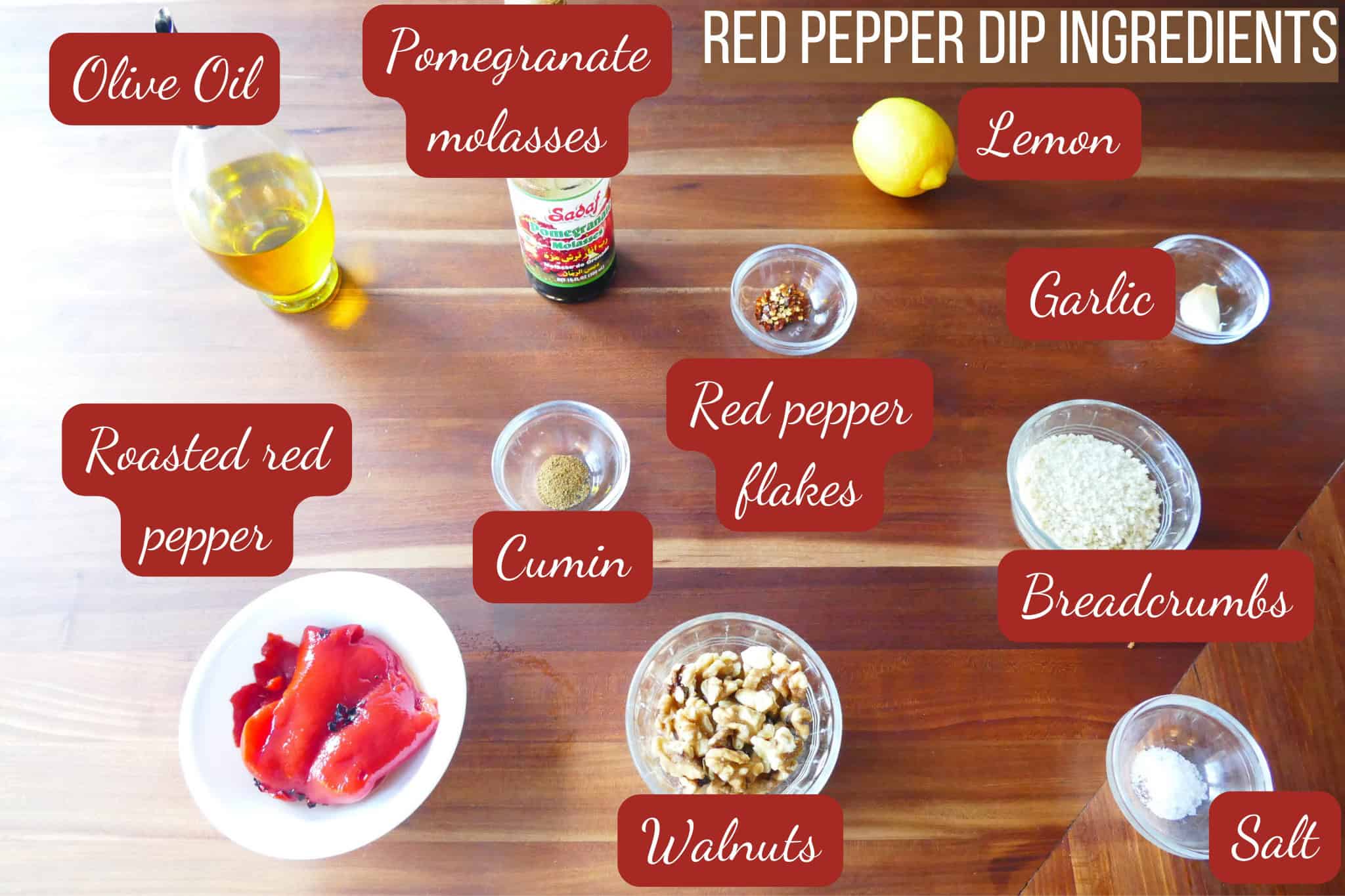 Muhammara red pepper dip ingredients on wooden counter.