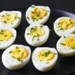 Eight halved Instant Pot 1-minute hard boiled eggs on plate.